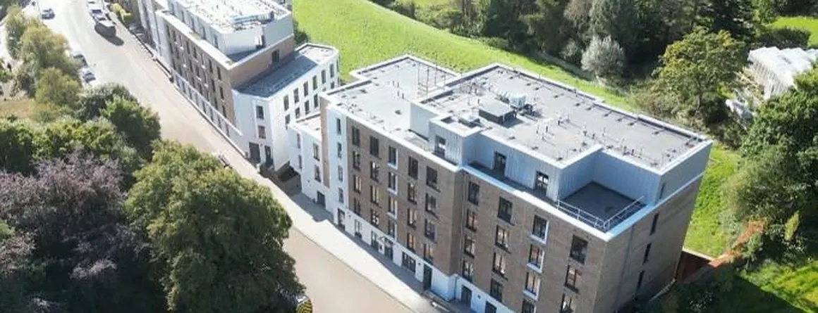 Apartmenthaus in der Luftaufnahme mit Flachdach und begrünter Umgebung