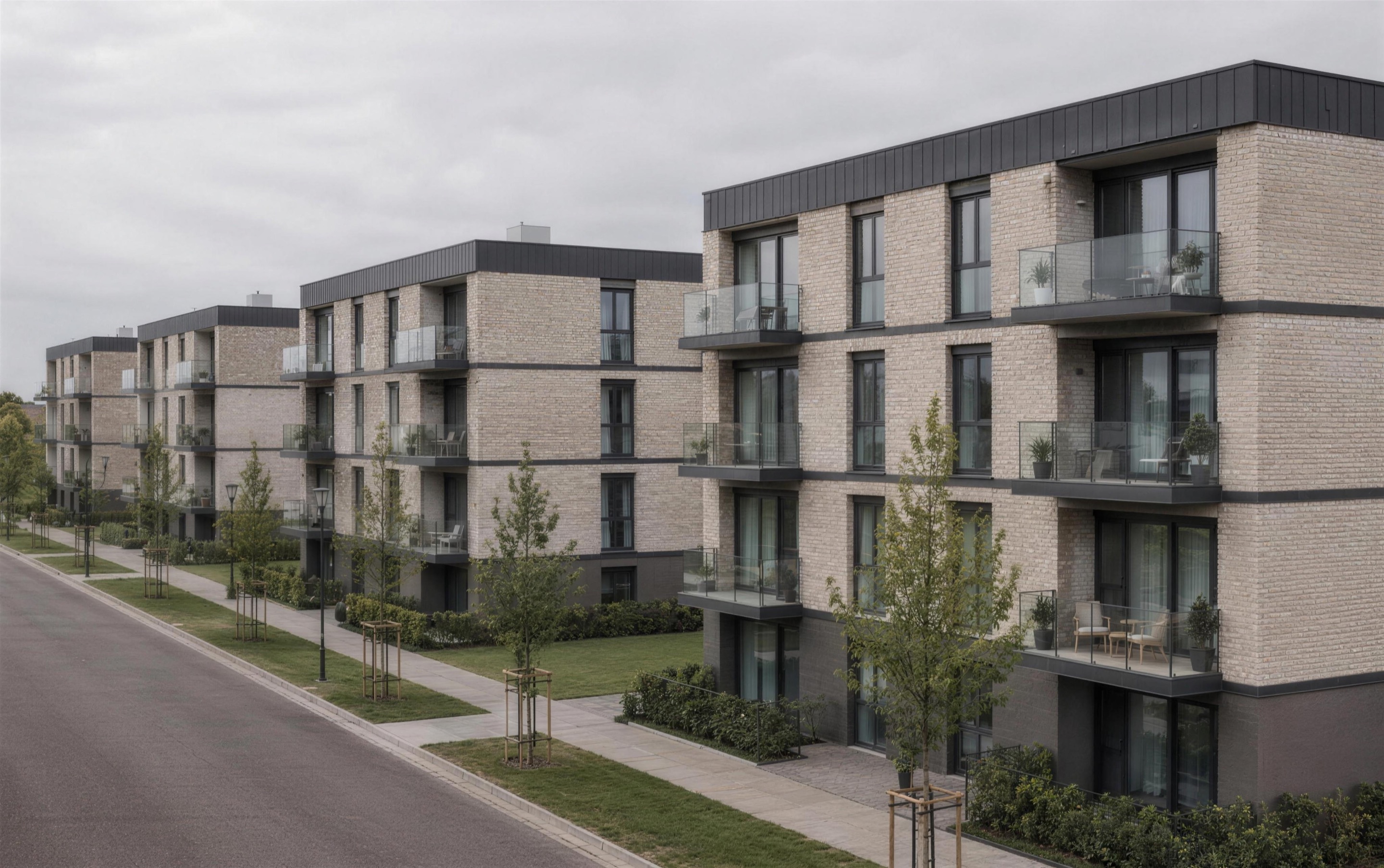 Mehrere fertiggestellte Wohngebäude derselben Modulbauweise in einer Zeile, mit Klinkerfassade und Balkonen